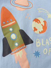 Close-up detail of the rocket, planet, and shooting star graphic on light blue fabric