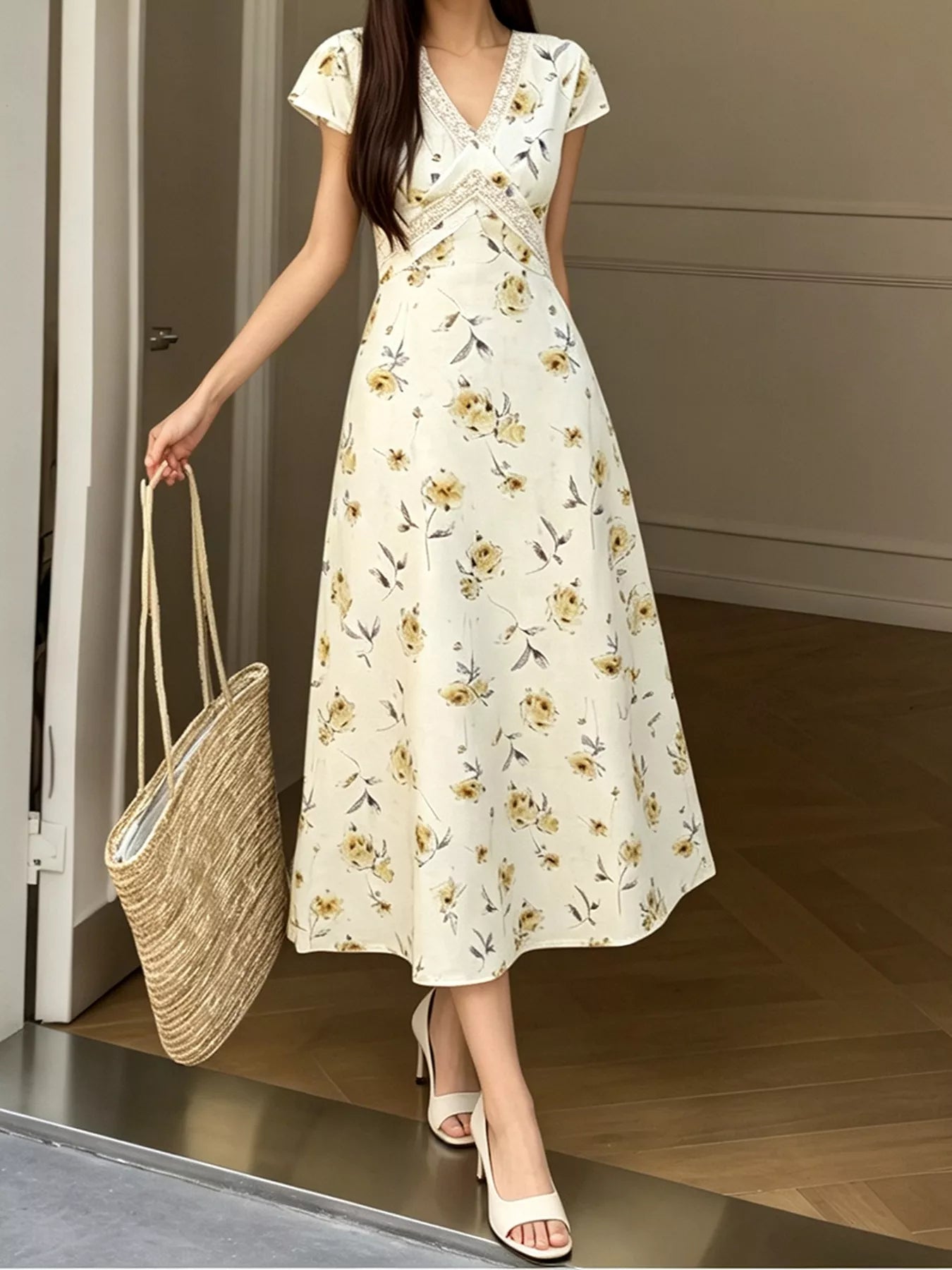 Full length front view of a yellow floral midi dress with lace trimmed V neck on a model