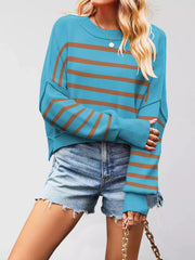 Front view of a turquoise sweater with brown stripes, crew neck, and dropped shoulders worn with denim shorts.