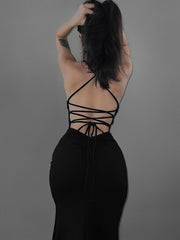 Black bodycon dress with crisscross lace up ties at the open back viewed from behind