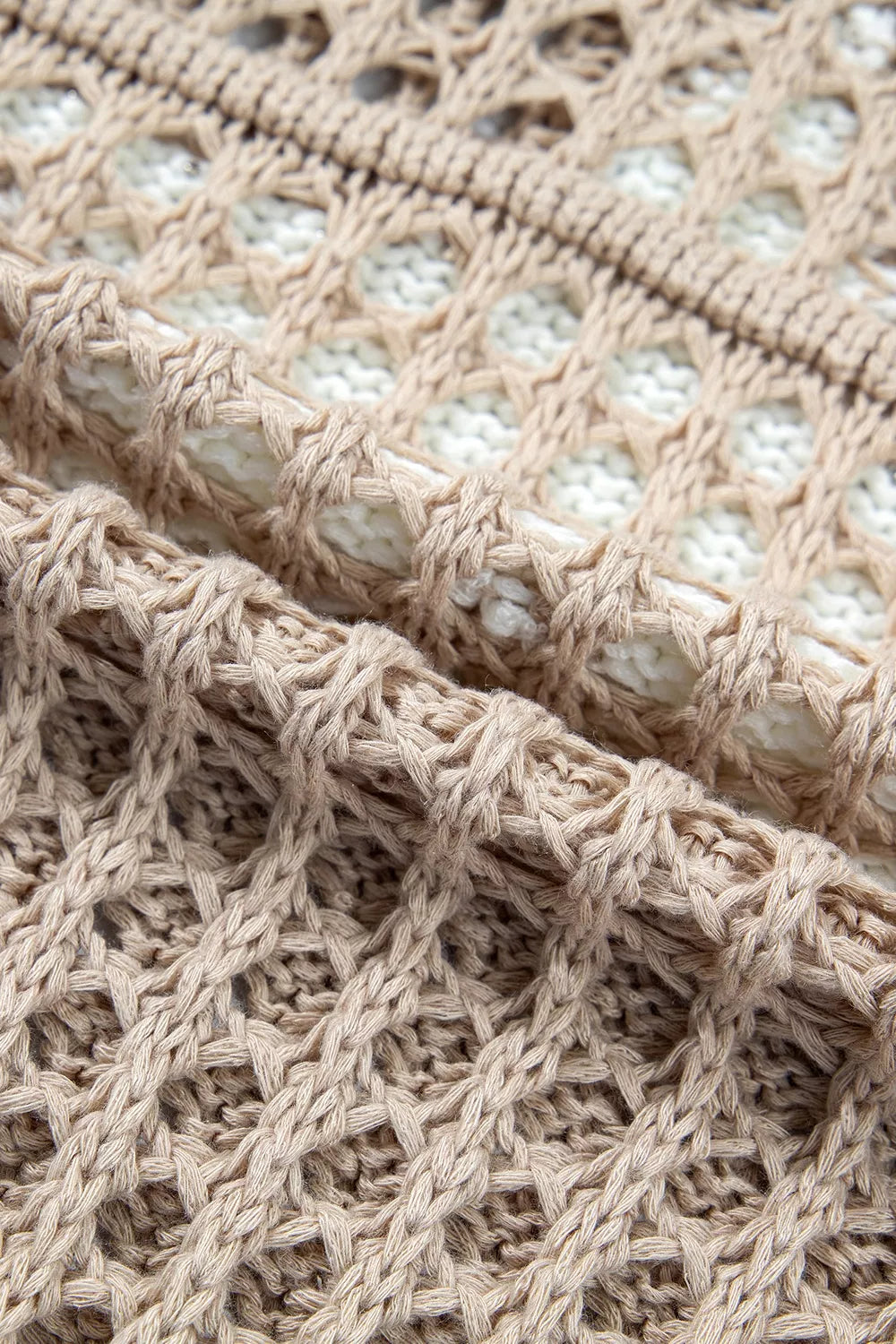 Close view of mocha openwork crochet fabric and edge of the white star detail.