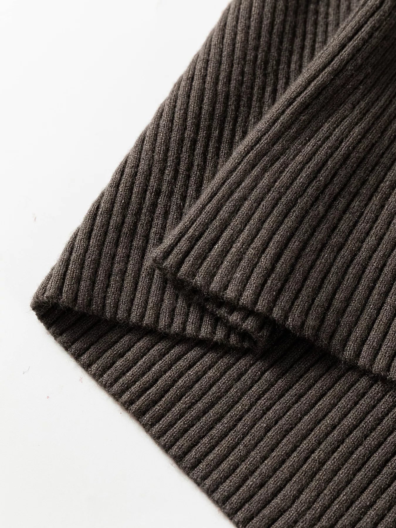 Close up detail of coffee brown ribbed hem on folded sweater vest