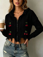 Black knit zip up hooded sweater with red cherry appliques worn on model holding coffee