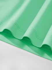 Close-up of the hem stitching and soft cotton fabric on the children's neon green t-shirt