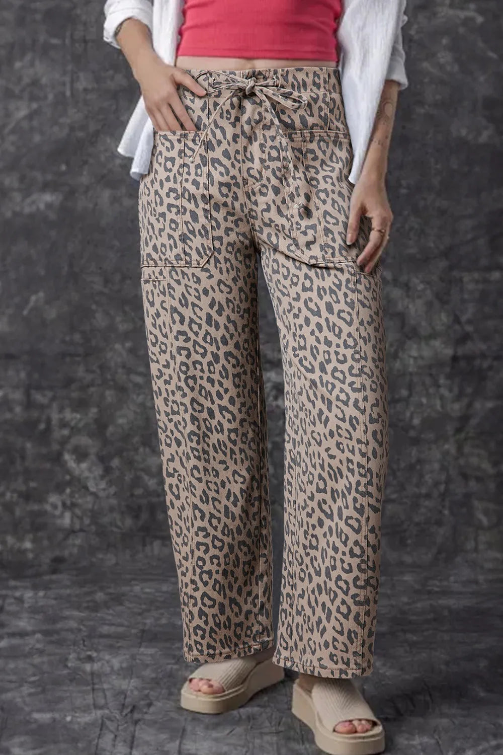 Women's leopard-print wide-leg jeans with a drawstring waist and pockets.