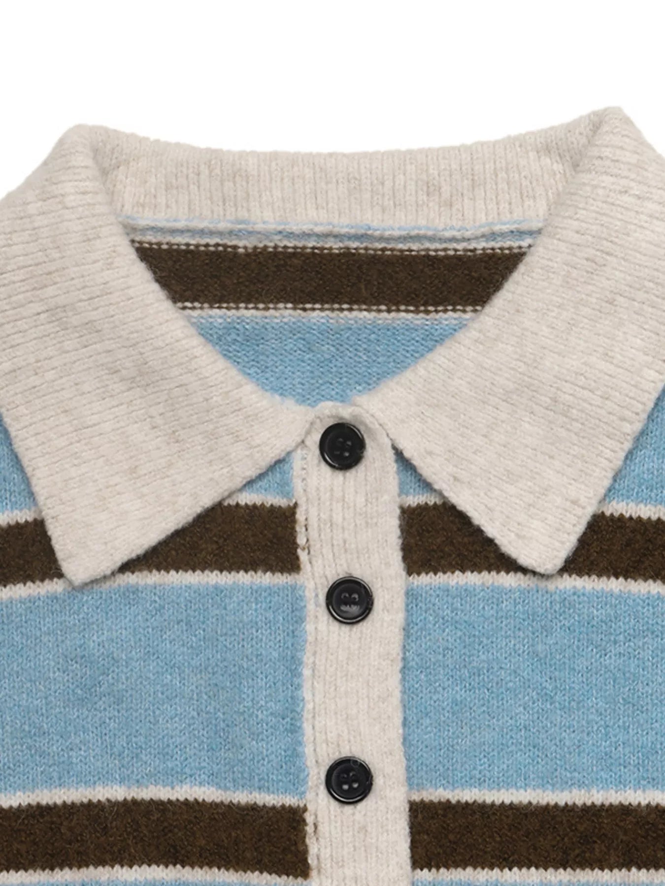 Close up of cream polo collar and black buttons on striped blue sweater.