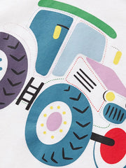 Close up of the cartoon tractor cab and large patterned wheels on the white T-shirt