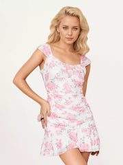 White ruched bodycon mini dress with pink rose floral print shown in a three quarter front view