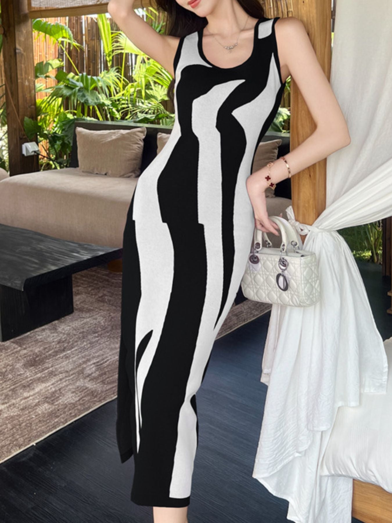 Black and white wavy contrast sleeveless bodycon midi dress worn full length indoors at an angle