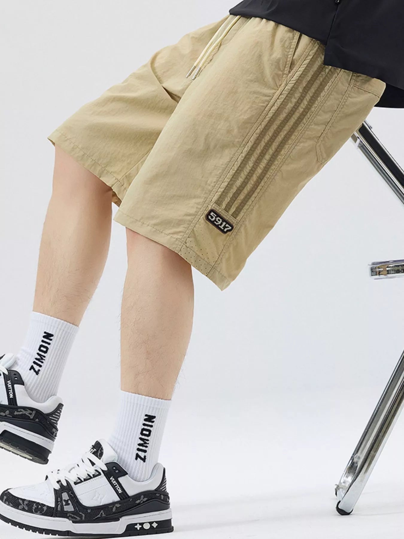 Men's khaki loose-fit shorts with stripe detail, a drawstring waist and pockets.
