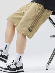 Men's khaki loose-fit shorts with stripe detail, a drawstring waist and pockets.