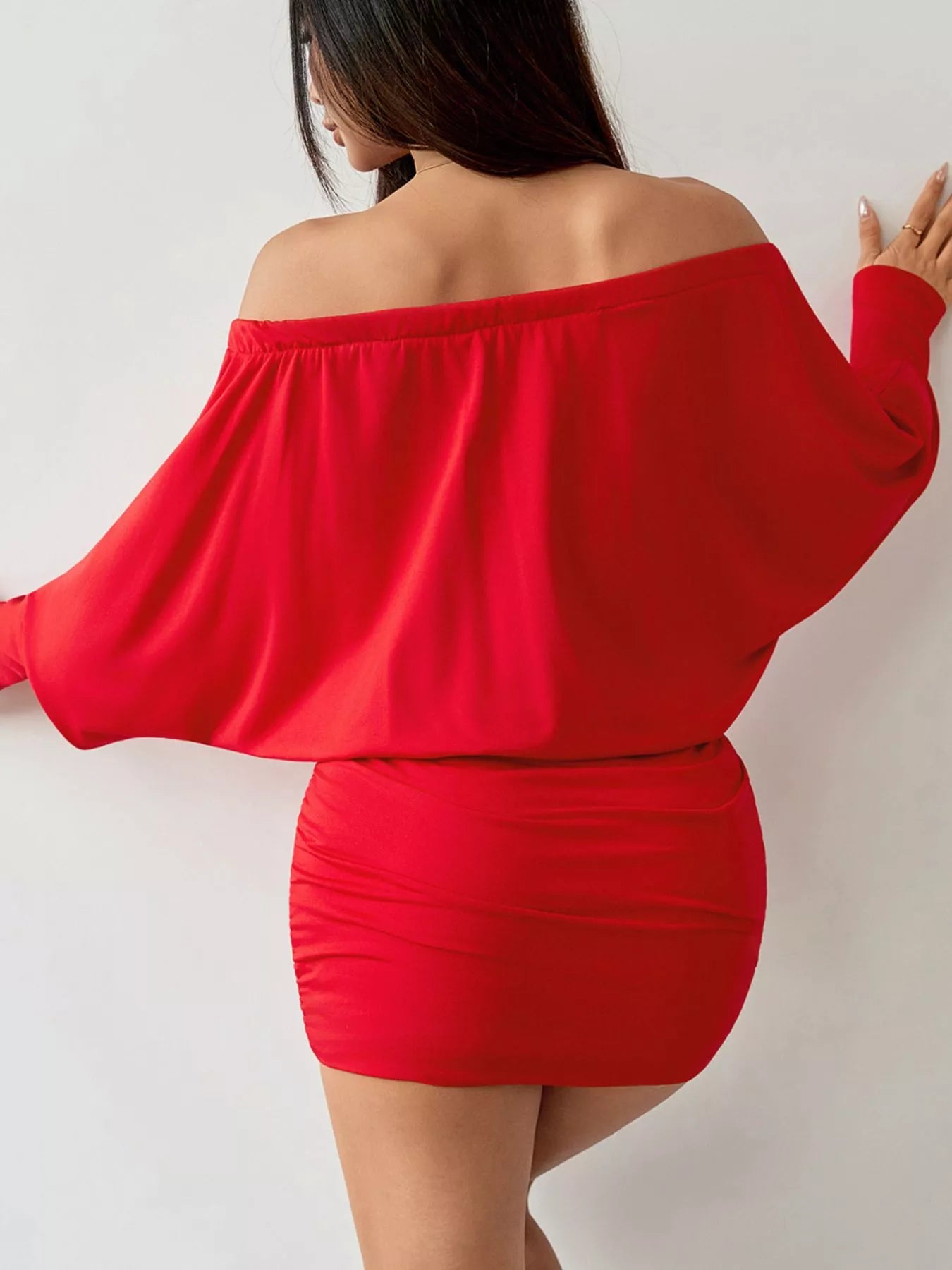 Red off shoulder mini dress with loose sleeves and ruched skirt, back view on model