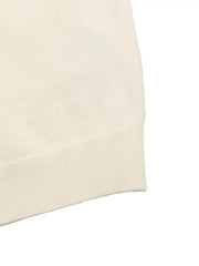 Close up of cream knit top ribbed hem and fine knit texture flat lay