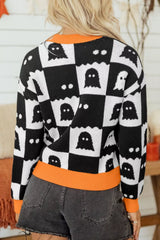 Back view of a black and white ghost checkerboard sweater with orange neck and hem