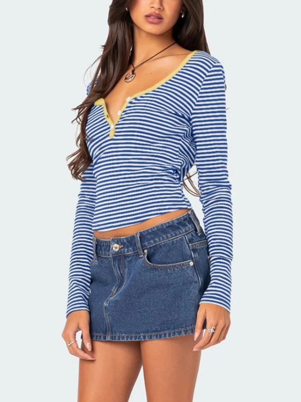 Three quarter front view of royal blue and white striped long sleeve t shirt with pale yellow button placket