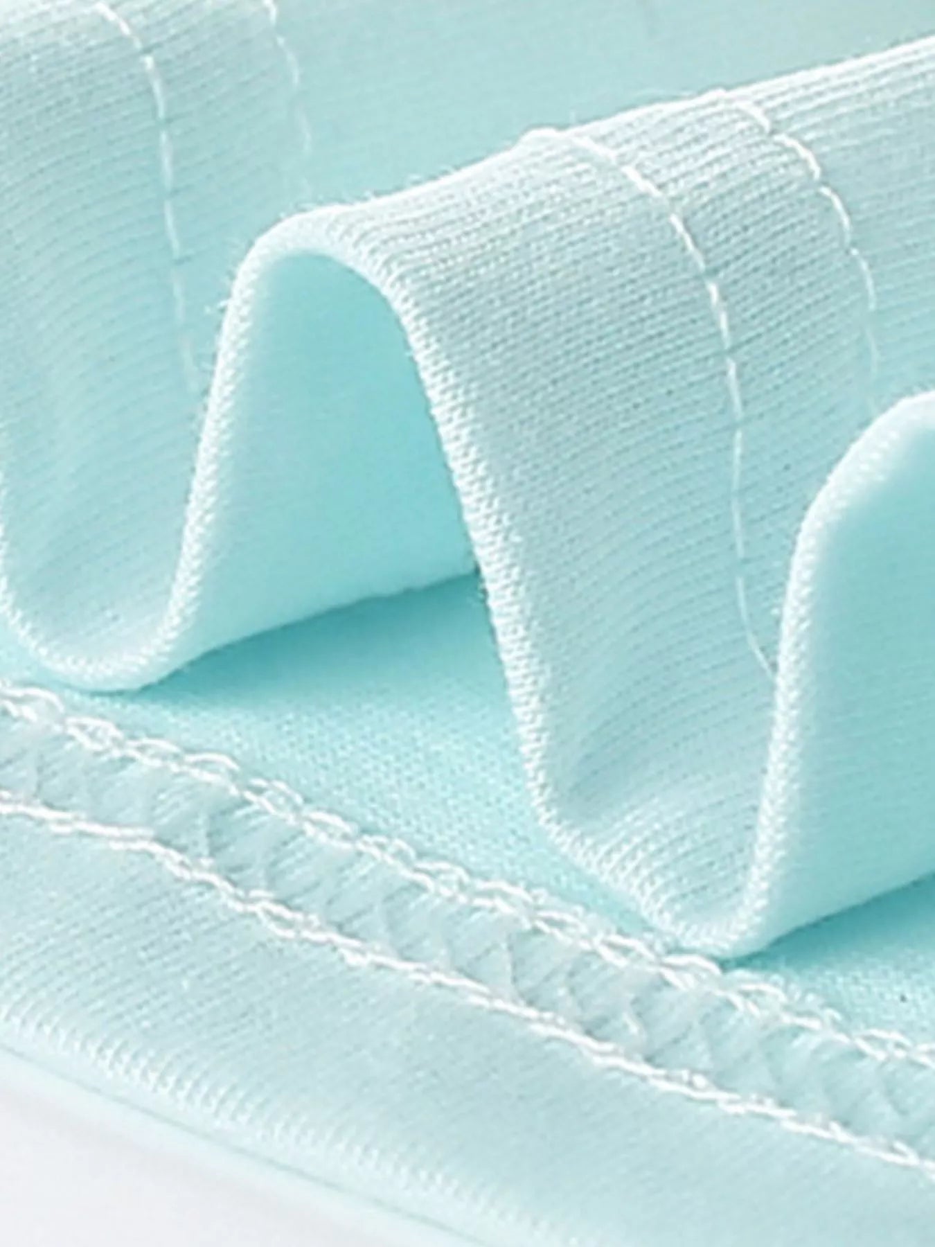 Close-up of mint blue children's t-shirt folded hem stitching and knit fabric detail
