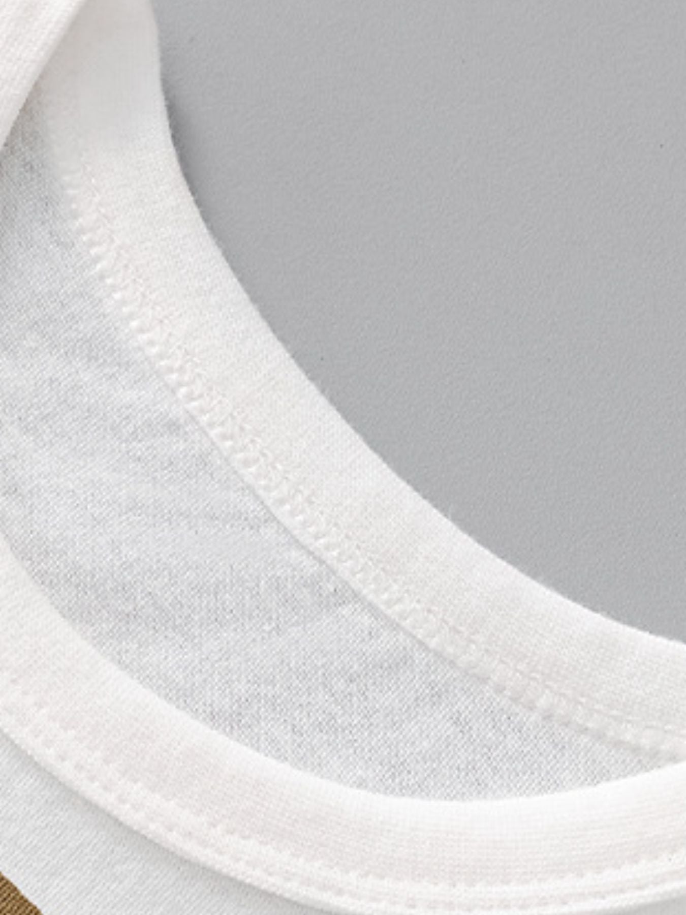 Close view of the white crew neckline stitching on the children's dinosaur t-shirt