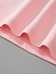 Close-up of the blush pink fabric and stitching at the hem of the children's t-shirt