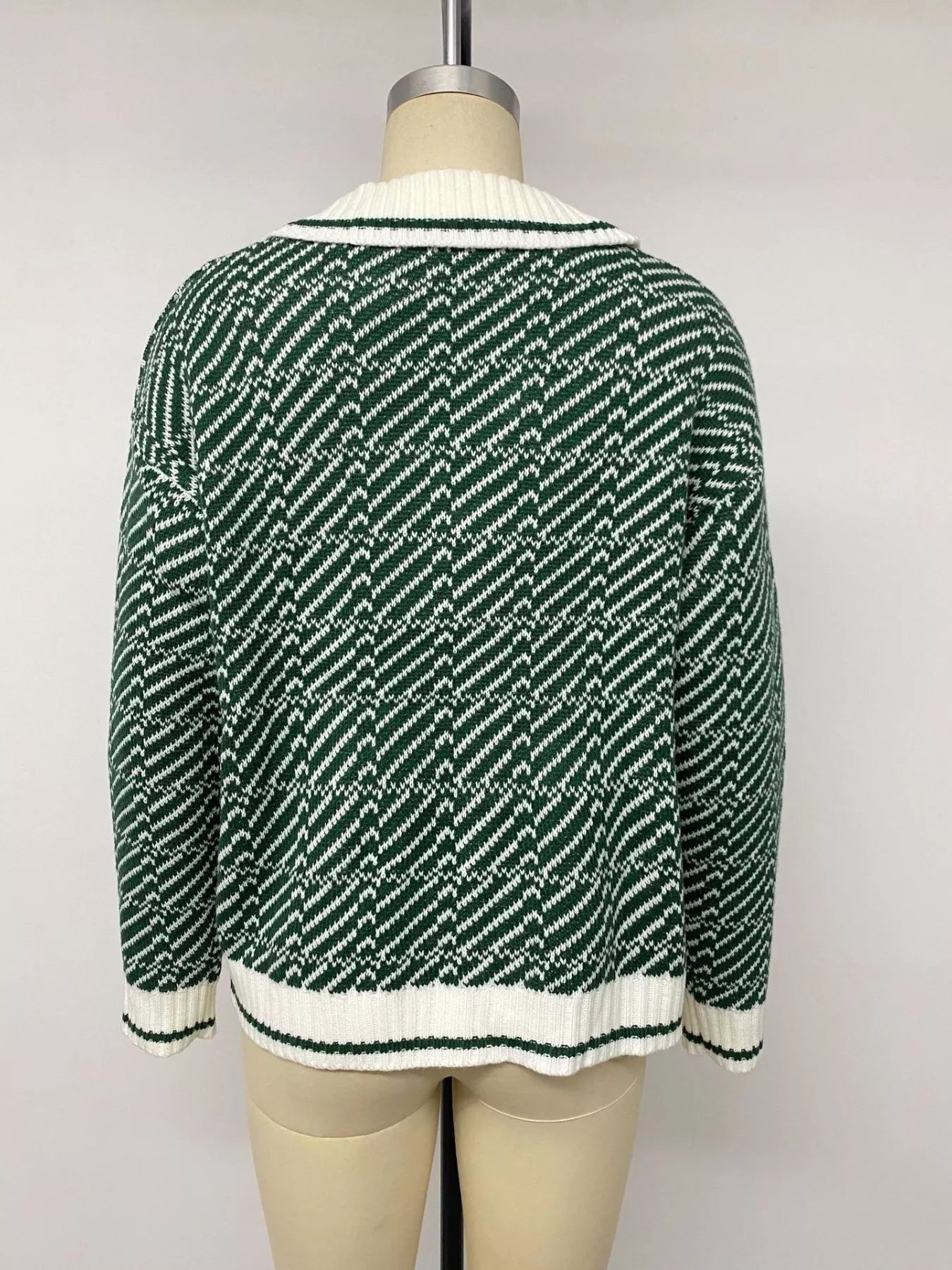 Back view of the green and white geometric collared sweater on a mannequin