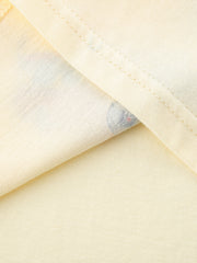 Close-up of the cream fabric and double stitching at the hem of the children's tee