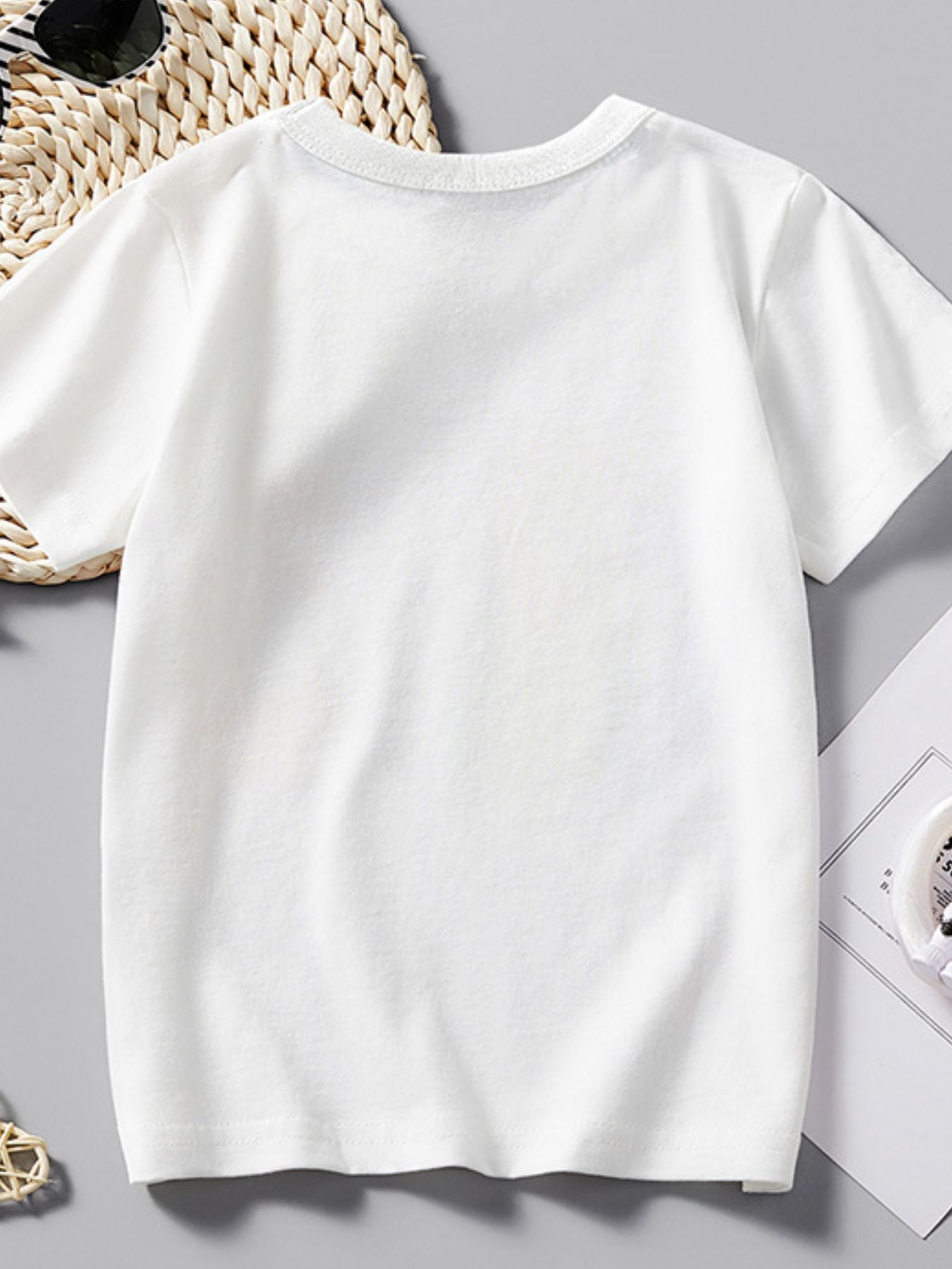 Back view of plain white children's short sleeve tee laid flat