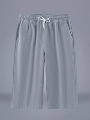 Men's light gray cropped casual pants with a drawstring waist and pockets.