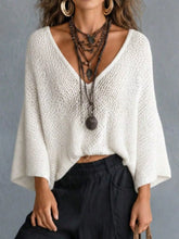 Front view of white V neck batwing sleeve sweater with loose open knit texture.