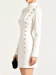 Side view of model in studio wearing white mock neck mini dress with gold decorative buttons
