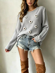 Front view of a light gray textured knit sweater with white floral appliques and long sleeves