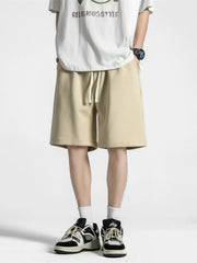 Men's khaki loose-fit casual shorts with a drawstring waist.