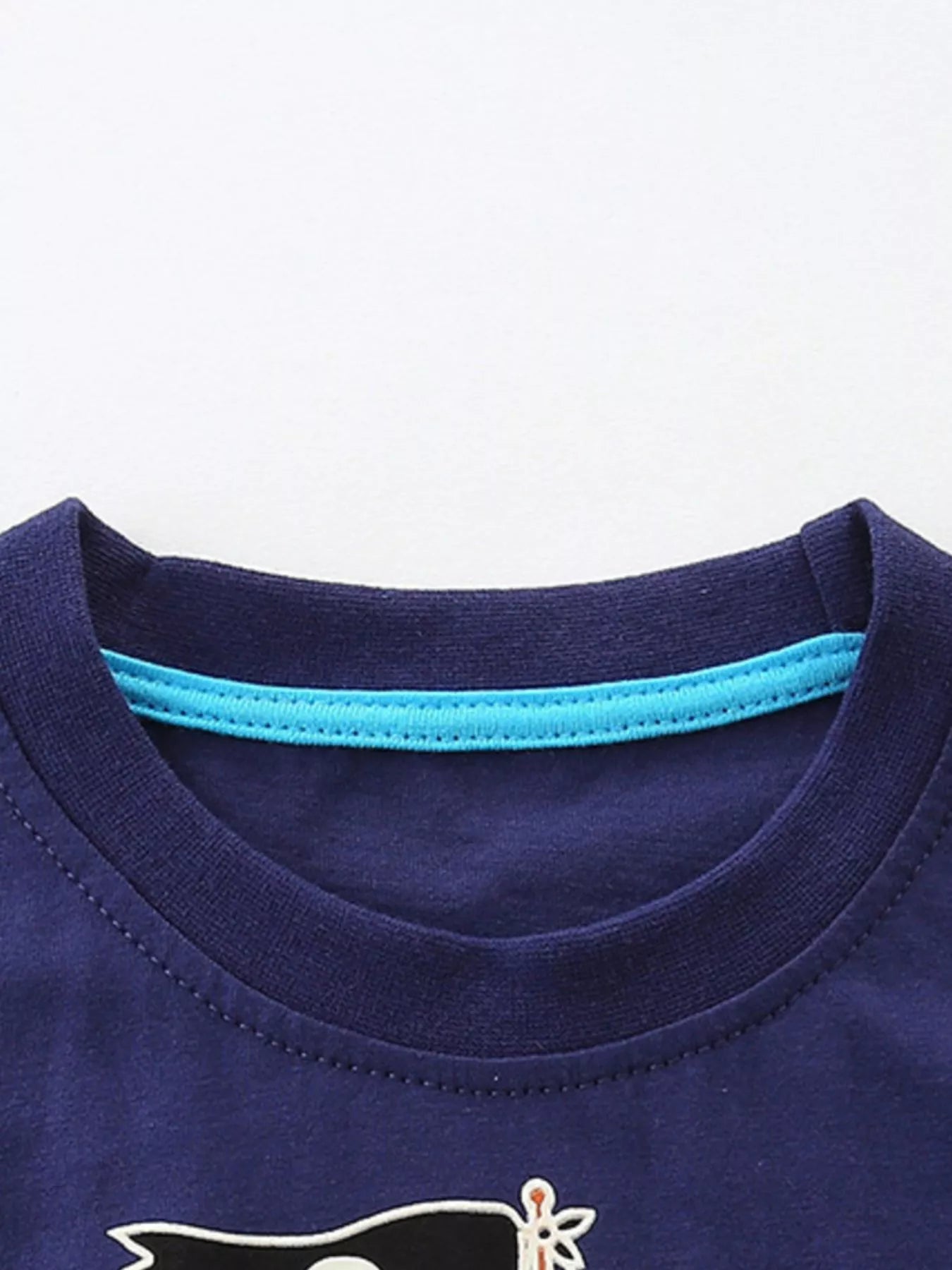 Close-up of the dark navy round neckline with bright blue inner trim and neat stitching