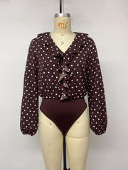 Mannequin front view of a coffee brown polka dot bodysuit with a ruffled V neckline
