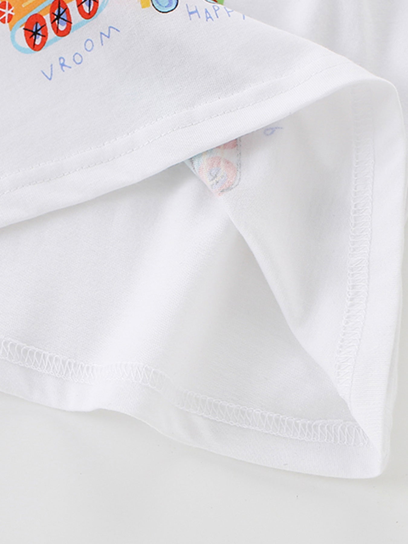 Detail view of the folded white hem and inner stitching on a children's construction vehicle crew neck t-shirt