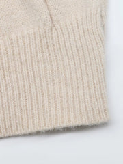 Close up of beige cable knit sweater dress ribbed hem showing soft knit texture
