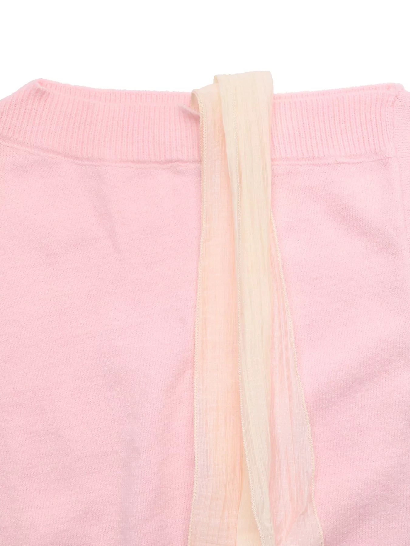 Close-up flat lay of a pink sweater neckline with a long cream ribbon tie