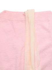 Close-up flat lay of a pink sweater neckline with a long cream ribbon tie