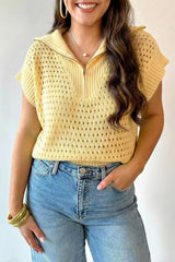 Front view of a pastel yellow openwork knit top with half zip collar, worn with jeans.