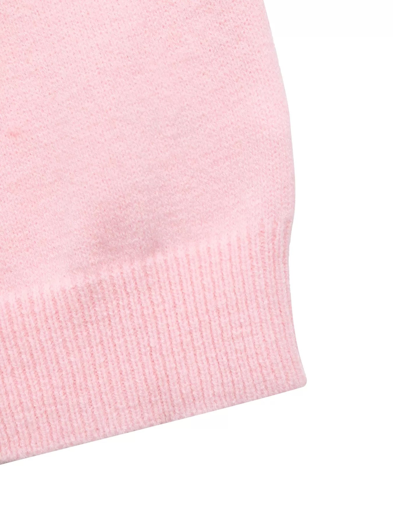 Close-up of the ribbed pink hem of a soft knit one-shoulder sweater