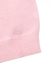 Close-up of the ribbed pink hem of a soft knit one-shoulder sweater