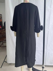 Back view of the black round neck midi dress on a mannequin with floral sleeve cuffs