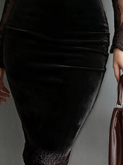 Detail view of the velvet skirt and lace hem of a black long sleeve bodycon dress