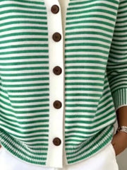 Close-up of the lower front and ribbed hem of a green and white striped knit cardigan