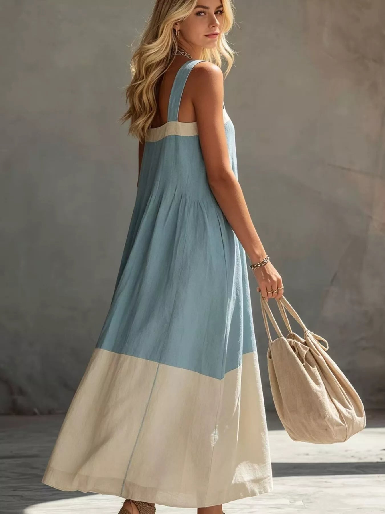 Back three quarter view on model of light blue color block sleeveless midi dress