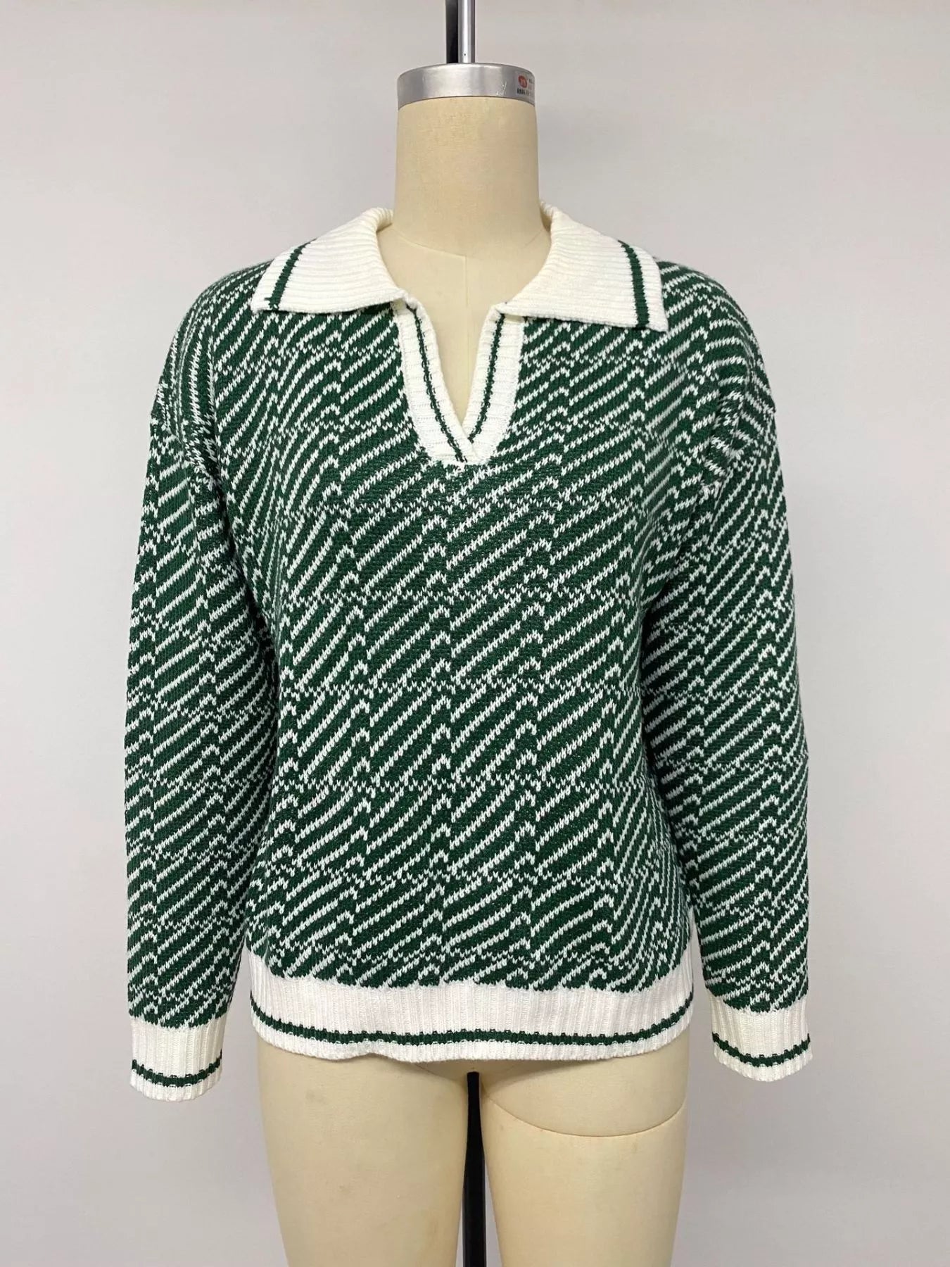Front view of the green and white geometric collared sweater on a mannequin