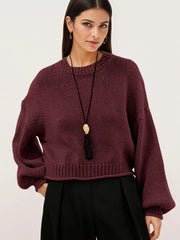 On-model front view of a burgundy oversized chunky knit sweater with balloon sleeves