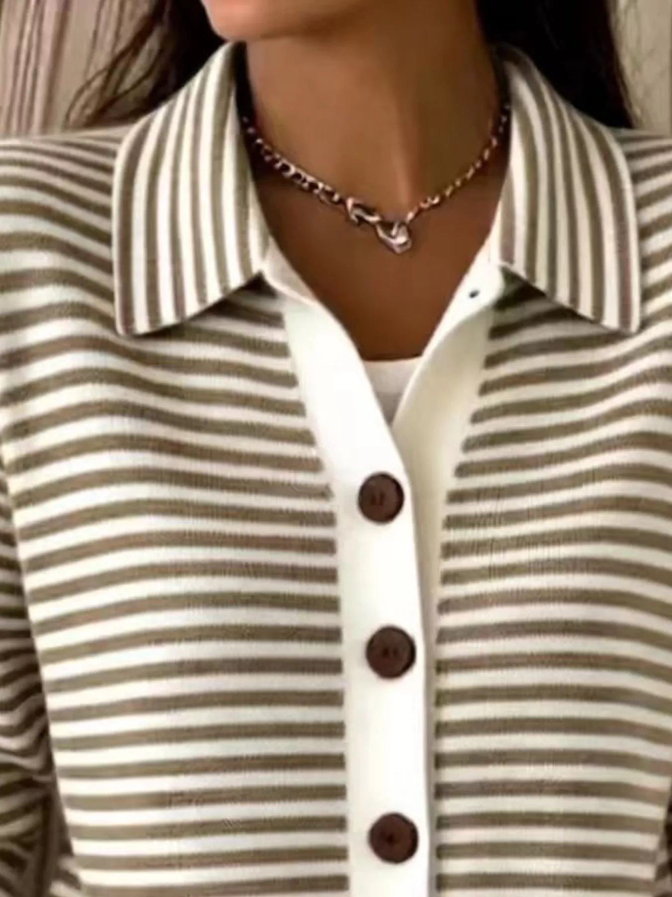 Close-up of the collar and brown buttons on a brown and white striped knit cardigan