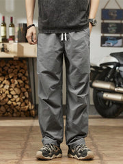 Men's dark gray relaxed-fit casual pants with a drawstring waist and pockets.