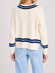 Back view of a cream cable knit sweater with navy and light blue striped trim