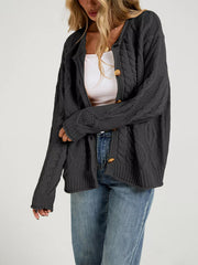 Side view of open dark gray cable knit cardigan over a white top with blue jeans