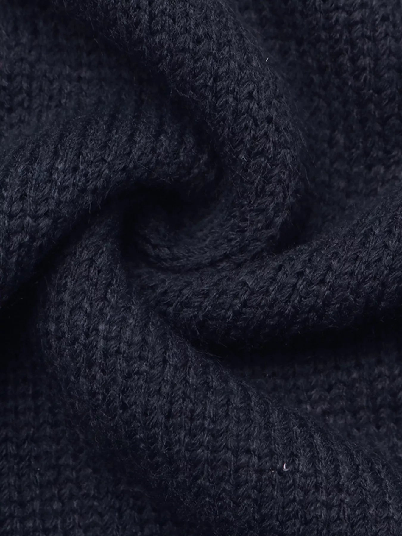 Close up of soft navy knit fabric in a swirled fold showing fine texture